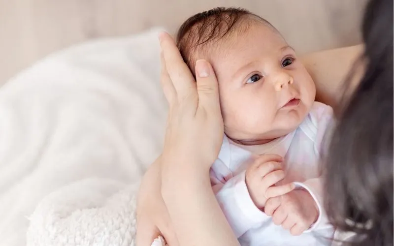 Dùng tay bịt lỗ tai hoặc hai cánh mũi của bé